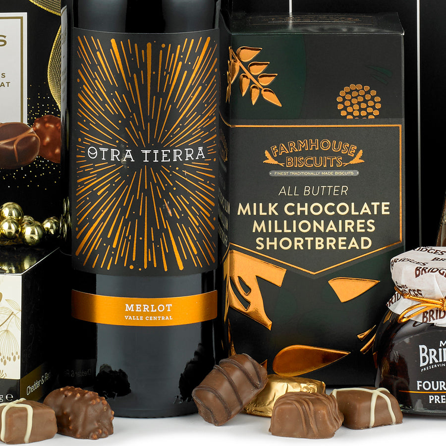 A closer look at the bottle of Merlot red wine from The Celebration red wine gift box sold by Thornton & France. Alongside sweet treats like the all butter milk chocolate millionaires shortbread by Farmhouse Biscuits.