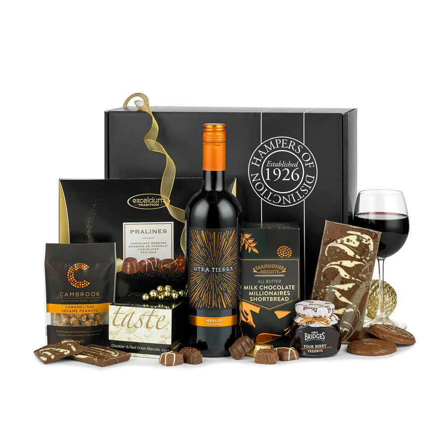 The full view of the Red Wine Celebration gift box, packed with the centrepiece of a bottle of red wine merlot. Surrounded by chocolate, peanuts, pralines & more.